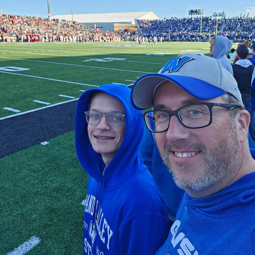 at GVSU football game are Mike Eichberger and his stepson Tristan, both are wearing Laker blue
